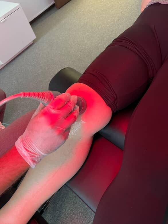 Therapist performing ultrasound therapy on a patient's shoulder